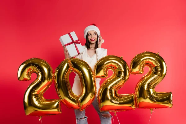 Smiling Woman Santa Hat Talking Smartphone Holding Gift Balloons Shape — Stock Photo, Image