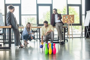 Ofiste bowling oynayan pozitif ırklar arası iş adamları 