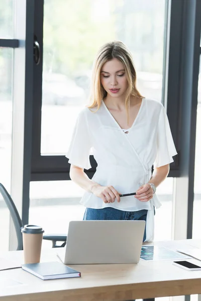 Joven Empresaria Sosteniendo Pluma Cerca Dispositivos Mesa Oficina — Foto de Stock