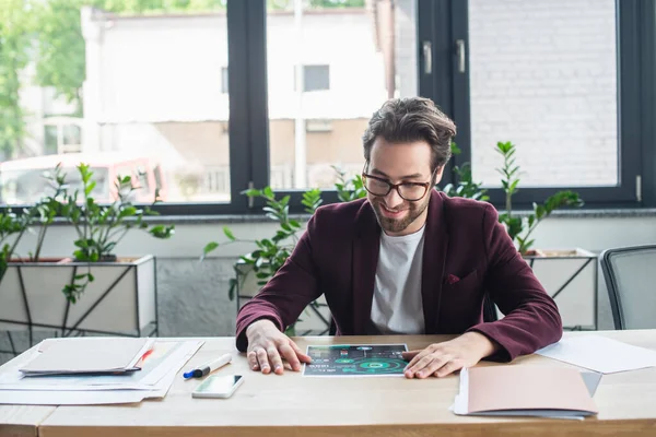 Empresário Sorridente Olhando Para Gráficos Perto Smartphone Escritório — Fotografia de Stock