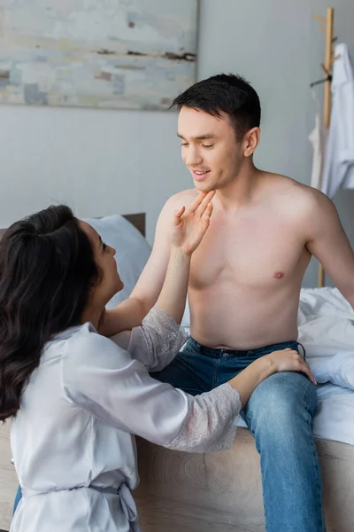 Sensual Young Woman Silk Robe Touching Face Smiling Boyfriend Bedroom — Stock Photo, Image