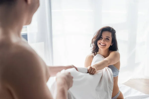 Blurred Man Pulling Blanket Happy Sexy Girlfriend — Stock Photo, Image