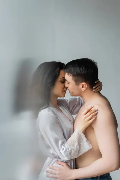 年轻夫妇在卧室接吻的侧视图 — 图库照片