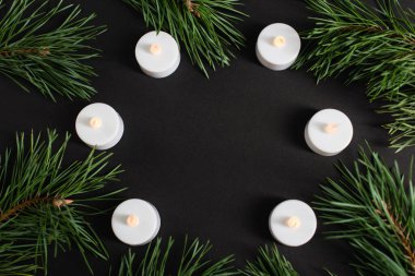 top view of candles and pine branches on black clipart