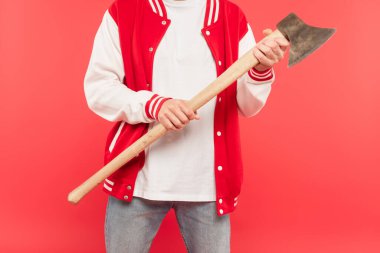 cropped view of man holding axe isolated on red clipart