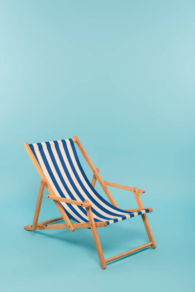 striped deck chair on blue background 