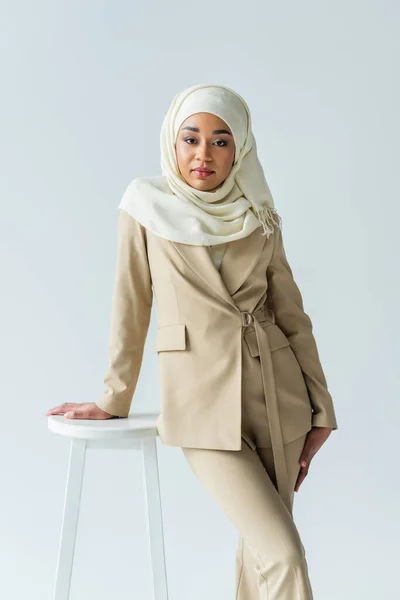 Mulher Muçulmana Elegante Hijab Terno Encostado Nas Fezes Isolado Cinza — Fotografia de Stock