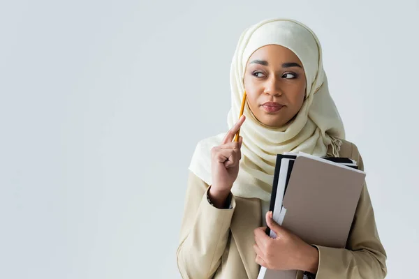 Mulher Muçulmana Pensativo Hijab Segurando Lápis Pastas Isoladas Cinza — Fotografia de Stock