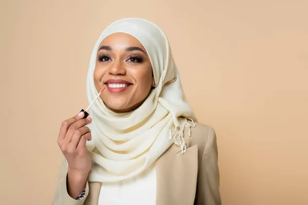 Happy Muslim Woman Hijab Applying Lip Gloss Isolated Beige — Stock Photo, Image