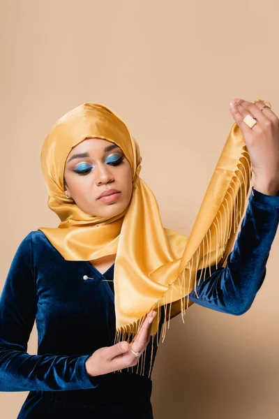 Mujer Musulmana Joven Con Maquillaje Brillante Sosteniendo Pañuelo Aislado Beige —  Fotos de Stock