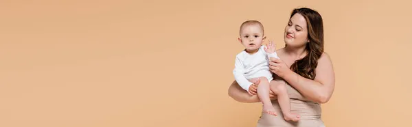 Sonriente Madre Sosteniendo Hija Del Bebé Agitando Mano Aislada Beige — Foto de Stock