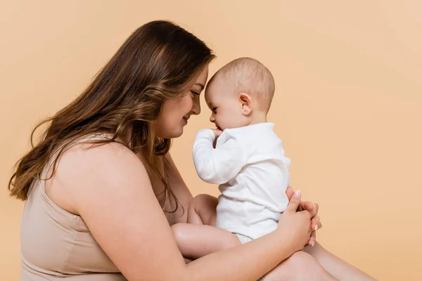 Vista Lateral Mujer Con Sobrepeso Sosteniendo Hija Bebé Aislado Beige — Foto de Stock