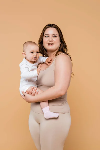 Šťastná Žena Nadváhou Drží Dítě Odvrací Pohled Béžové — Stock fotografie