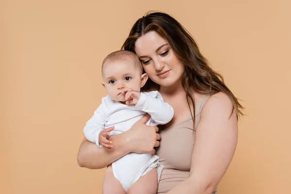Jovem Mãe Com Sobrepeso Segurando Bebê Isolado Bege — Fotografia de Stock