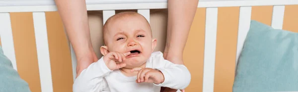 Más Tamaño Mujer Sosteniendo Llorando Hija Cuna Aislado Beige Pancarta — Foto de Stock