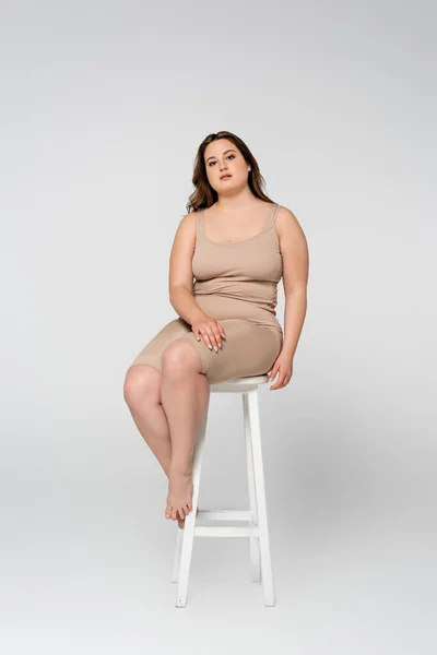 Pretty Size Woman Looking Camera While Sitting Chair Grey Background — Stock Photo, Image