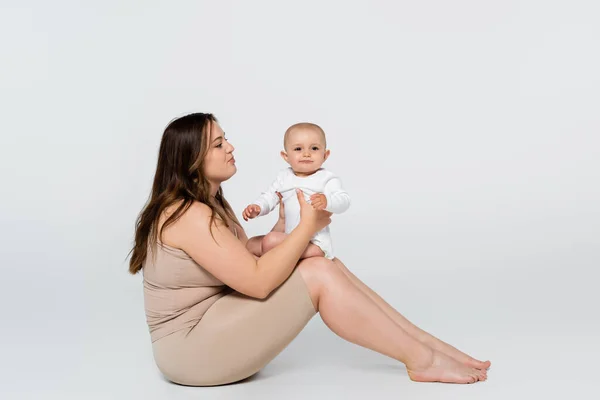 Young Woman Overweight Holding Child While Sitting Grey Background — Stock Photo, Image