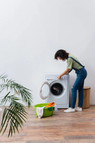 Morena Mujer Operando Lavadora Cerca Ropa Tazón Lavandería — Foto de Stock