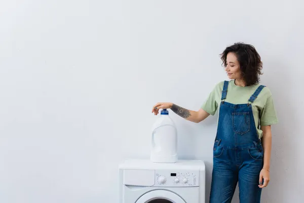 Glimlachende Huisvrouw Staan Buurt Van Fles Wasmiddel Wasmachine — Stockfoto