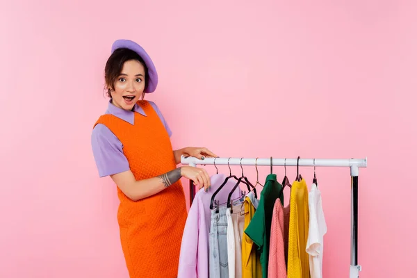 Mujer Asombrada Vestido Anaranjado Sin Mangas Mirando Cámara Cerca Rack — Foto de Stock