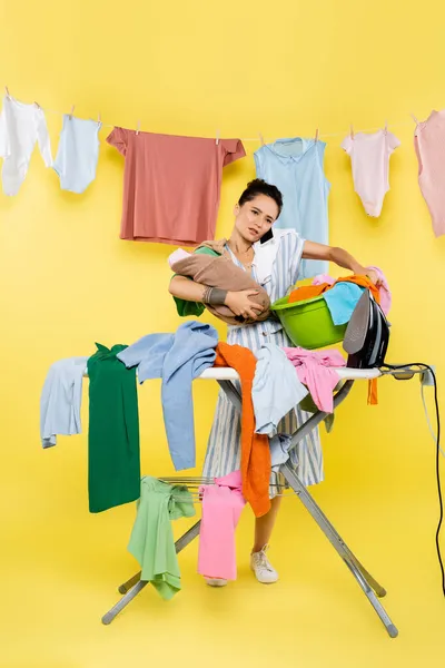 Woman Talking Smartphone While Holding Baby Doll Laundry Bowl Pile — ストック写真