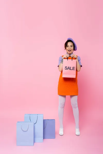 Donna Stupita Mostrando Shopping Bag Con Lettere Vendita Vicino Agli — Foto Stock