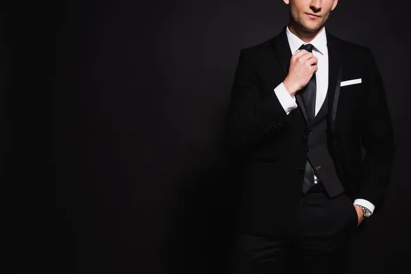 典雅男子手牵手站在黑色口袋里摸领带的局部画面 — 图库照片