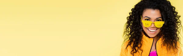 笑着的非洲裔美国年轻女子 戴着太阳镜 挂着黄色横幅的销售字母 — 图库照片