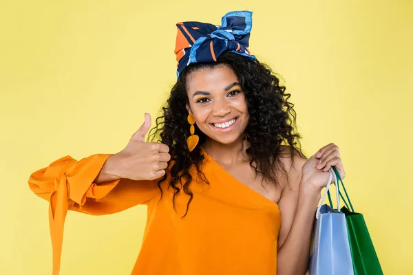 Smiling African American Woman Holding Shopping Bags Showing Thumb Isolated — Stock Photo, Image