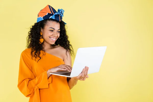 Gülümseyen Afrikalı Amerikalı Kadın Sarı Dizüstü Bilgisayar Kullanıyor — Stok fotoğraf