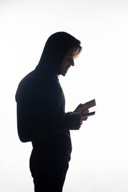 Cep telefonu ve kredi kartı tutan hackerın yan görüntüsü beyaza izole edildi 