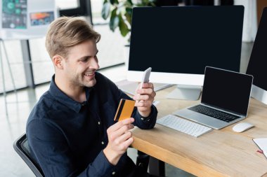 Ofisteki bilgisayarların yanında akıllı telefon ve kredi kartı kullanan pozitif geliştirici 