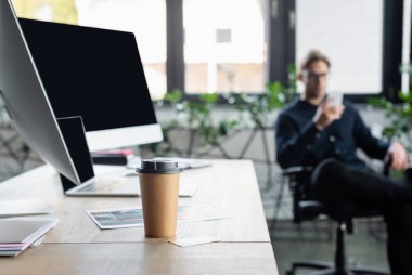 Bilgisayarların yanına gitmek için kahve ve ofiste bulanık programcı 