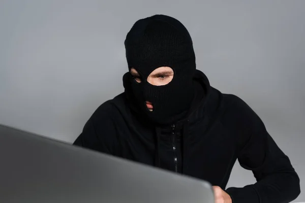 Hacker Mit Sturmhaube Blickt Auf Computermonitor Isoliert Auf Grau — Stockfoto