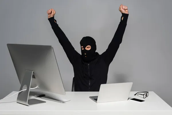 Spännande Hacker Balaclava Visar Gest Nära Prylar Grå Bakgrund — Stockfoto