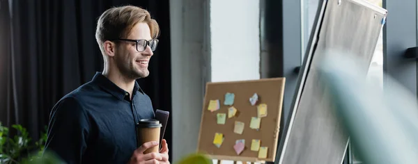 Glimlachende Programmeur Met Koffie Papier Map Zoek Naar Flip Banner — Stockfoto