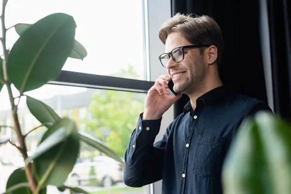 Programmer Positif Dalam Kacamata Berbicara Smartphone Dekat Tanaman Kantor — Stok Foto