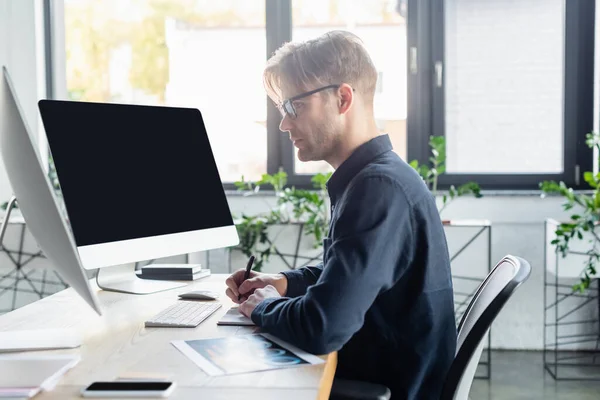 Vista Lateral Desarrollador Escribiendo Portátil Cerca Computadoras Con Pantalla Blanco — Foto de Stock