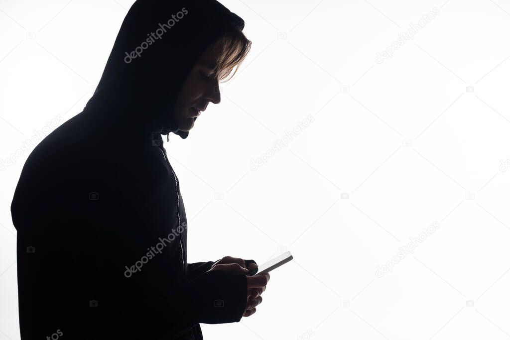 Side view of hacker using smartphone isolated on white 