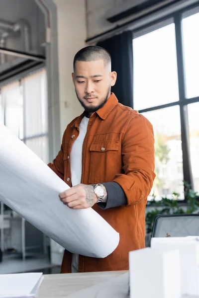 Asian Architect Looking Blurred House Models While Holding Blueprint Office — Stock Photo, Image