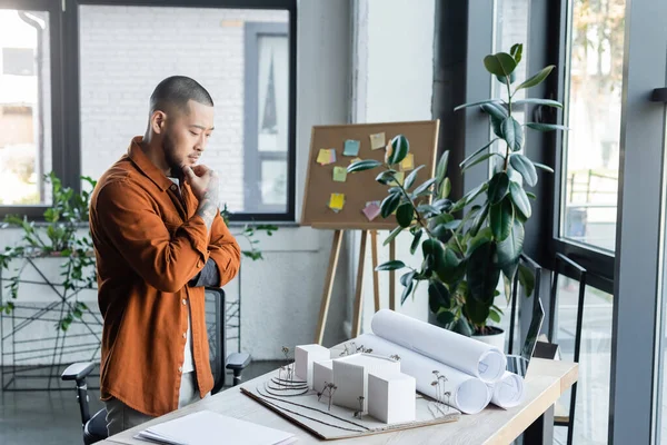 Přemýšlivý Asijský Architekt Při Pohledu Dům Modely Pracovním Stole Kanceláři — Stock fotografie