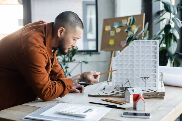 Asiatischer Ingenieur Zeigt Mit Bleistift Auf Hausmodell Während Architekturprojekt Arbeitet — Stockfoto