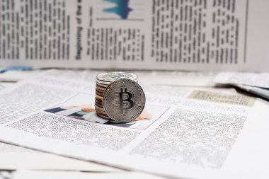 KYIV, UKRAINE - 1 Kasım 2021: basılı gazete üzerindeki metalik bitcoinler 