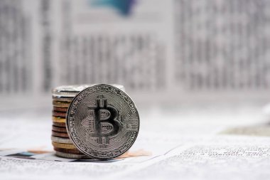 KYIV, UKRAINE - Kasım 1, 2021: basılı gazete üzerindeki metalik bitcoinlere yakın çekim 