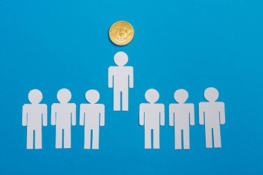 Beyaz kağıdın üst görüntüsü, insanları mavi ve lider kavramları üzerine altın bitcoin 'in yanında sıraya dizdi. 