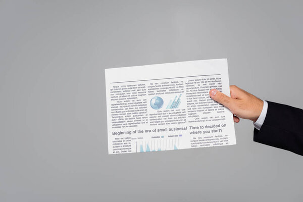 обрезанный вид человека, держащего газету изолированной на сером