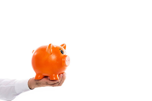 cropped view of man holding orange piggy bank isolated on white