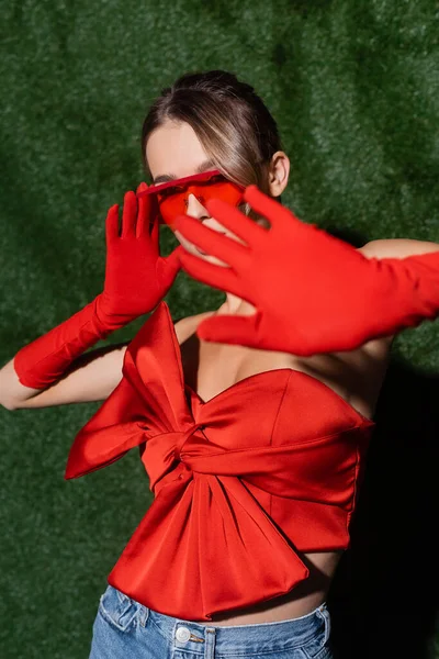 Stylish Woman Red Blouse Sunglasses Gloves Showing Gesture Grassy Background — Stock Photo, Image