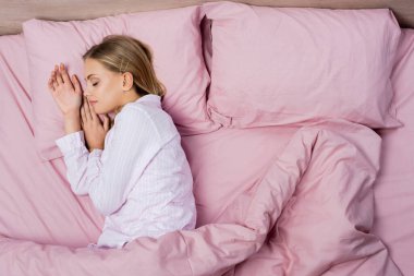 Pijamalı bir kadının evde pembe bir yatakta uyuduğu en iyi manzara.