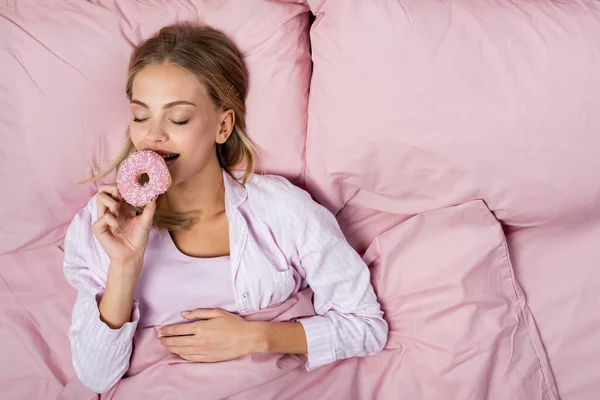 Top View Smiling Woman Pajama Holding Donut Pink Bed — Stock Photo, Image